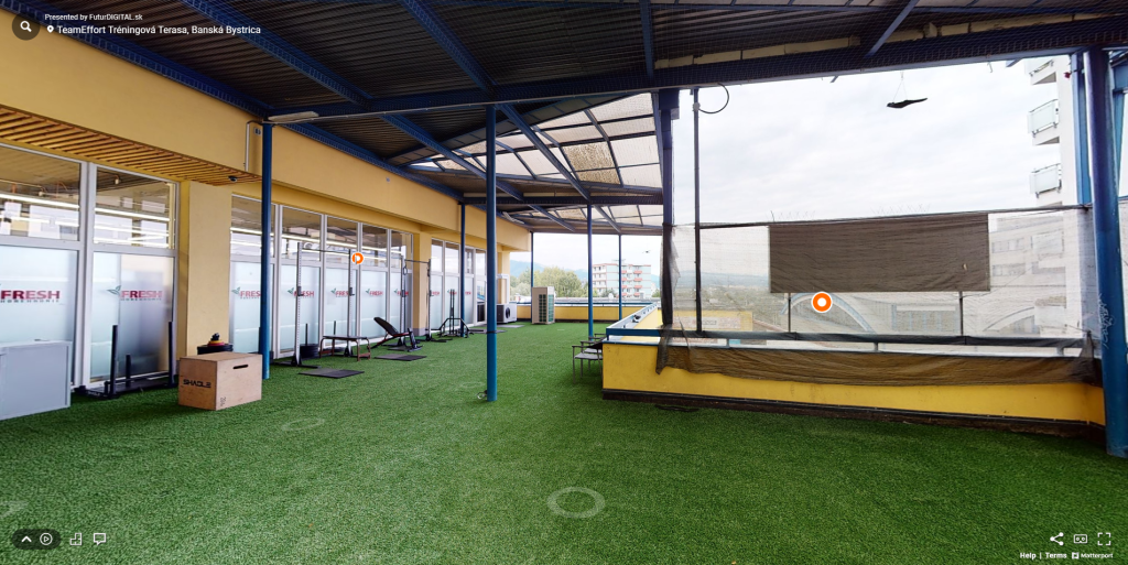 Pohľad na virtuálnu prehliadku terasy fitnesscentra Team Effort so záberom na plochu s umelým trávnikom a cvičiacimi pomôckami.